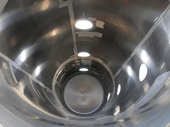 View into a cylindrical steel pressure vessel with nozzles and a dished end